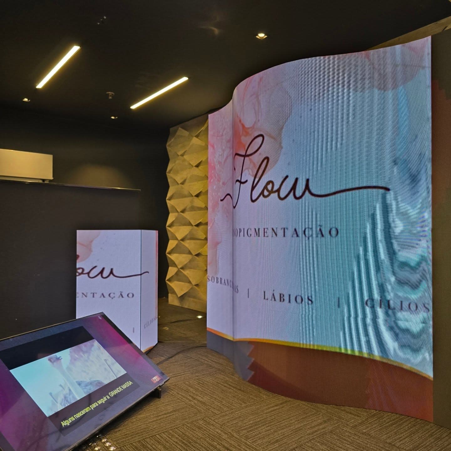Parede curva de painel de LED em ativação de marca, com totem touch integrado.
